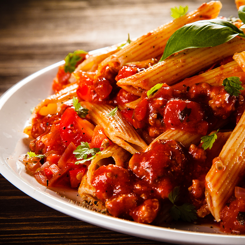 A plate of pasta with tomato sauce and basil.
